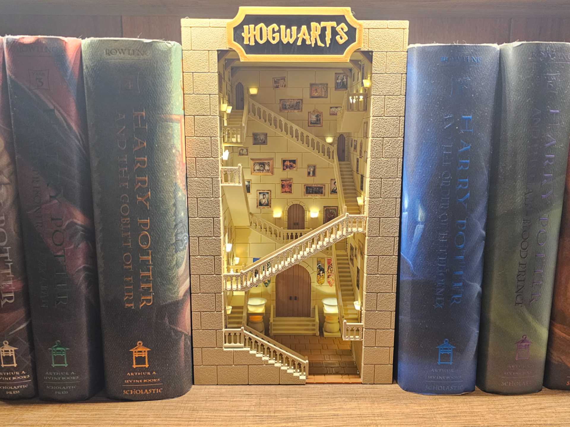 Harry Potter books with a model of Hogwarts castle in the center